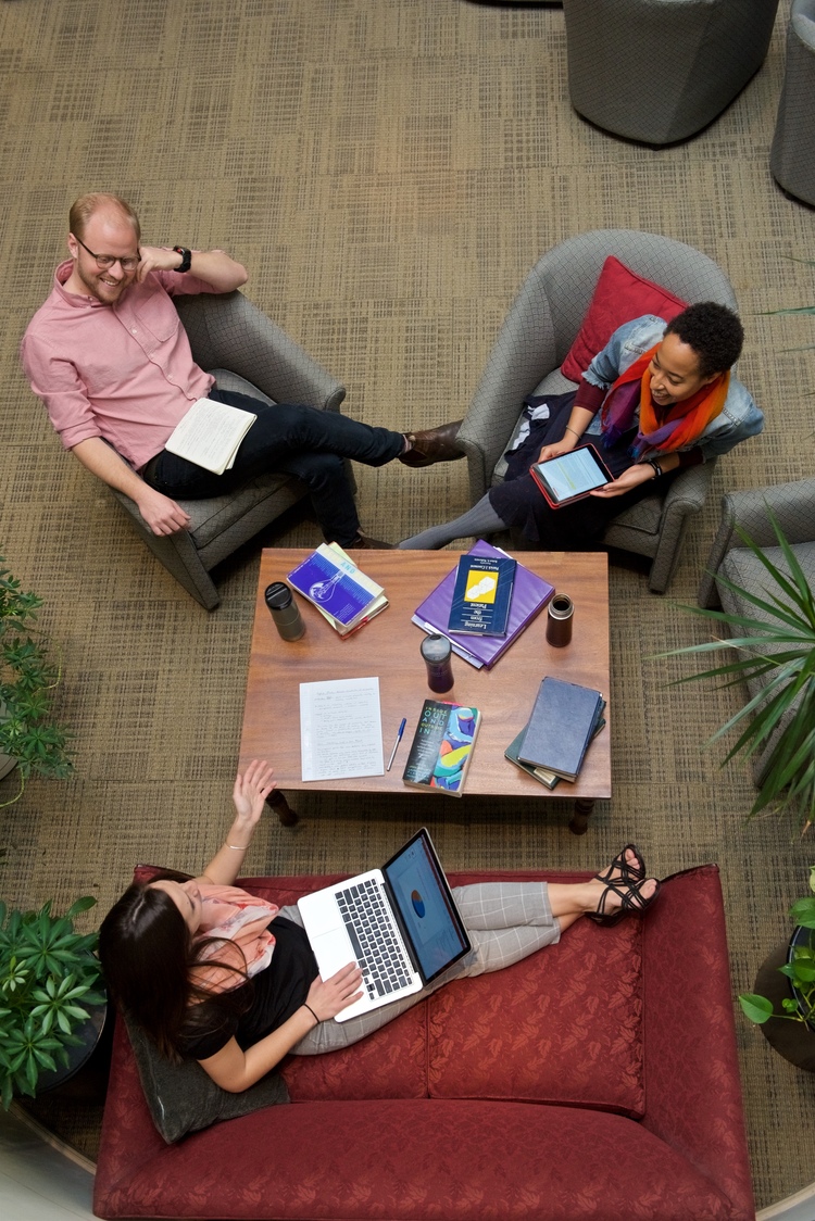 People at work chatting around a table. This is an example of small business branding photography